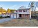 Two-story home with brick and vinyl siding, red shutters, an attached two-car garage, and a long driveway at 7025 Kimberly Mill Rd, Atlanta, GA 30349