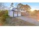 Two-story home featuring a two-car garage, a brick chimney, vinyl siding, and a long driveway in a wooded area at 7025 Kimberly Mill Rd, Atlanta, GA 30349