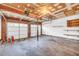 Spacious garage with bare concrete floor, storage shelves, and two-car door at 7025 Kimberly Mill Rd, Atlanta, GA 30349