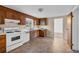 Classic kitchen featuring wood cabinets, white appliances, and a tiled floor at 7025 Kimberly Mill Rd, Atlanta, GA 30349