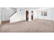 Spacious living room featuring neutral carpet, white walls, a staircase, and a view of the kitchen and dining area at 7025 Kimberly Mill Rd, Atlanta, GA 30349