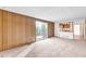 Open living room with paneled walls and sliding glass door to deck at 7025 Kimberly Mill Rd, Atlanta, GA 30349
