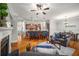 Open-concept living room with a kitchen island, fireplace, hardwood floors, and a gray sofa at 10416 Park Walk Pt, Alpharetta, GA 30022