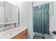 Bathroom features a sink with vanity, mirrored medicine cabinet, and a shower with a green curtain at 2002 Wingate Rd, Atlanta, GA 30341