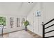 Sunlit foyer with white walls, a modern front door and views of the wooded lot through the windows at 2626 Shadow Woods Ne Cir, Marietta, GA 30062
