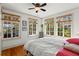 Bright bedroom features wood floors, three windows offering backyard views, and a large, comfortable bed for relaxation at 2653 Brookwood Ne Dr, Atlanta, GA 30305