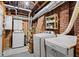 Spacious laundry room with washer, dryer, sink, storage cabinets, and exposed brick at 2653 Brookwood Ne Dr, Atlanta, GA 30305