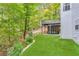 Manicured backyard oasis with artificial turf, a covered patio, and tiered landscaping at 3882 The Ascent Ne, Brookhaven, GA 30319