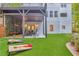 Inviting backyard with covered patio, yard games, artificial turf, and tiered landscaping at 3882 The Ascent Ne, Brookhaven, GA 30319
