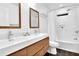 Modern bathroom with double sink vanity, wood cabinets, and tiled shower with a rain shower head at 3882 The Ascent Ne, Brookhaven, GA 30319