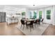 Dining area with a large wooden table, modern lighting, and large windows with beautiful natural light at 3882 The Ascent Ne, Brookhaven, GA 30319