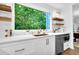 Updated kitchen boasts stainless steel appliances, white cabinets, and a large window with backyard view at 3882 The Ascent Ne, Brookhaven, GA 30319