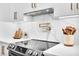 Bright kitchen featuring a modern stove with a stainless steel range hood and designer backsplash at 3882 The Ascent Ne, Brookhaven, GA 30319