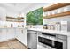 Open kitchen featuring stainless steel appliances, white cabinets and countertops, and wood shelves at 3882 The Ascent Ne, Brookhaven, GA 30319
