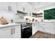 Well-lit kitchen with stainless steel stove, white cabinets and countertops, and wood grain flooring at 3882 The Ascent Ne, Brookhaven, GA 30319