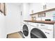 Well-organized laundry room with front loading washer and dryer with storage cabinets above at 3882 The Ascent Ne, Brookhaven, GA 30319