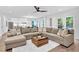 Bright living room with a large sectional couch, modern ceiling fan and view of the updated kitchen at 3882 The Ascent Ne, Brookhaven, GA 30319
