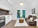 Bright sitting area with coffee bar featuring tiled backsplash, mini-fridge, and french doors to balcony at 3882 The Ascent Ne, Brookhaven, GA 30319