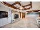 Spacious living room features a stone fireplace, and custom wood beam ceiling at 7010 Wakehurst Pl, Cumming, GA 30040