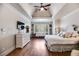 Spacious main bedroom with tray ceiling, hardwood floors, and a view of the seating area at 7010 Wakehurst Pl, Cumming, GA 30040