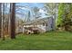 View of the backyard and deck of a two-story house, with a natural setting and green grass at 305 Bridgewater Ter, Canton, GA 30115
