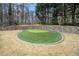 Lush backyard featuring a custom putting green surrounded by stone retaining wall and natural setting at 4040 Annecy Dr, Atlanta, GA 30331