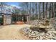 Backyard with stone waterfall, hot tub, and pergola set amongst mature trees and natural surroundings at 4040 Annecy Dr, Atlanta, GA 30331