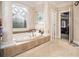 A stylish bathroom features a soaking tub under a decorative window, with tile surround and neutral colors at 4040 Annecy Dr, Atlanta, GA 30331