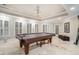 A game room is illuminated by recessed lighting, a pool table, and bright white shutters at 4040 Annecy Dr, Atlanta, GA 30331