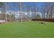 Expansive backyard with lush green grass, mature trees, and a cozy fire pit area for outdoor enjoyment at 618 Jenmarie Sw Dr, Mableton, GA 30126