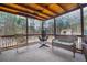 Inviting screened porch features rustic furnishings and a comfortable swing chair at 4558 Bronte Ln, Douglasville, GA 30135