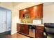 Convenient wet bar with dark wood cabinets and tiled backsplash at 4558 Bronte Ln, Douglasville, GA 30135