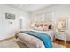 Bright bedroom featuring a bed with colorful cushions, white walls, and light-colored hardwood floors at 595 Ridgecrest Ne Rd, Atlanta, GA 30307
