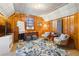 Cozy bonus room featuring wood paneling, a floral rug, and comfortable seating beneath the window at 595 Ridgecrest Ne Rd, Atlanta, GA 30307