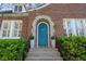 Close-up of the blue front door, surrounded by a stone archway and green landscaping at 595 Ridgecrest Ne Rd, Atlanta, GA 30307