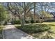 A brick home nestled among mature trees with a long driveway and lush, green landscaping at 595 Ridgecrest Ne Rd, Atlanta, GA 30307