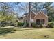 Classic brick home with a well-manicured lawn and mature trees, featuring a screened in porch at 595 Ridgecrest Ne Rd, Atlanta, GA 30307