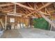 Inside a garage featuring wood beams, a partial concrete floor with a tarp, chairs, and shelves at 595 Ridgecrest Ne Rd, Atlanta, GA 30307