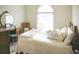 Cozy bedroom featuring a comfortable bed, natural light, and a decorative mirror at 3533 Saddlebrook Dr, Loganville, GA 30052
