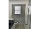 Stylish half-bathroom with tiled floors, a black marble countertop, and white molding and a window at 4617 N Peachtree Rd, Dunwoody, GA 30338