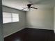 Comfortable bedroom featuring a ceiling fan, hardwood floors, and natural light from a bright window at 4617 N Peachtree Rd, Dunwoody, GA 30338