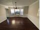 Formal dining room with hardwood floors, chandelier, and a bright bay window at 4617 N Peachtree Rd, Dunwoody, GA 30338