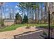 Expansive backyard with a fire pit, shed, and mature trees at 10015 Timberstone Rd, Alpharetta, GA 30022