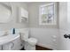 Cozy half bathroom with white wainscoting, modern fixtures, and a round mirror at 1007 Crown River Pkwy, Mcdonough, GA 30252