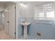Vintage bathroom features a pedestal sink, blue tile, and updated lighting at 2153 Starfire Drive Ne Dr, Atlanta, GA 30345
