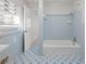 Retro bathroom features blue tile, a tub with shower, and an adjacent doorway at 2153 Starfire Drive Ne Dr, Atlanta, GA 30345