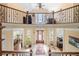 Open foyer with a balcony overlooking the grand entrance with decorative iron railing and travertine flooring at 3017 Canton Pines, Marietta, GA 30068