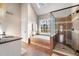 Bathroom featuring a glass-enclosed shower, a soaking tub, and a vanity with a granite countertop at 1701 Crowes Lake Ct, Lawrenceville, GA 30043