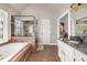 Bright bathroom featuring double vanity sinks, soaking tub, glass enclosed shower with tile surround at 1701 Crowes Lake Ct, Lawrenceville, GA 30043