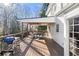Inviting covered wooden deck featuring a dining table, grill, ceiling fan, and backyard views at 1701 Crowes Lake Ct, Lawrenceville, GA 30043